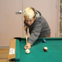 boy playing pool at The HYDE Out Teen Center