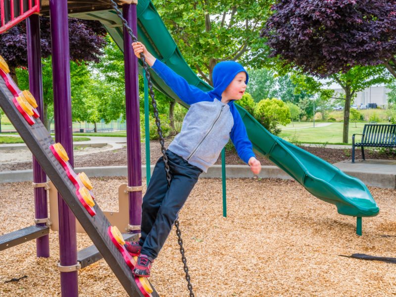 boy playing on playground at Stone Creek Community Park